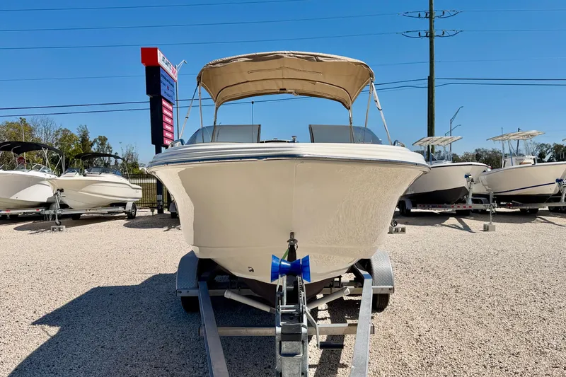 Slide: The Image of 2023 Scout 215 Dorado boat on trailer, displayed outdoors under clear blue sky. - 2