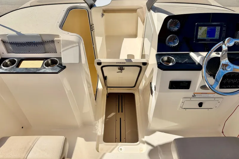 Slide: The Image of 2023 Scout 215 Dorado boat interior with storage, steering wheel, and navigation display. - 21
