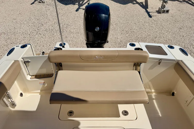 Slide: The Image of 2023 Scout 215 Dorado boat interior with beige seating and outboard motor. - 23