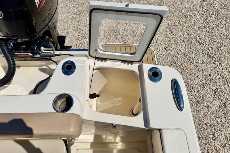 Slide: The Image of 2023 Scout 215 Dorado boat interior with open storage compartment and motor. - 24