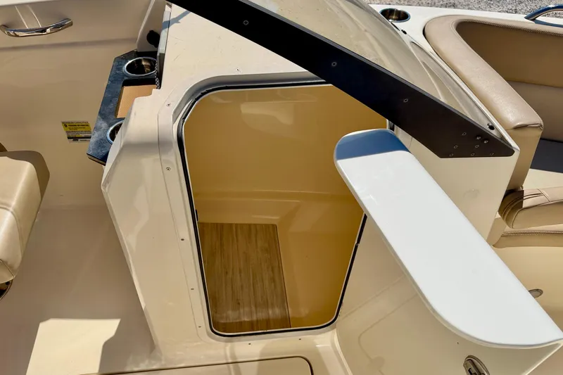 Slide: The Image of 2023 Scout 215 Dorado boat interior with open storage compartment and seating area. - 25