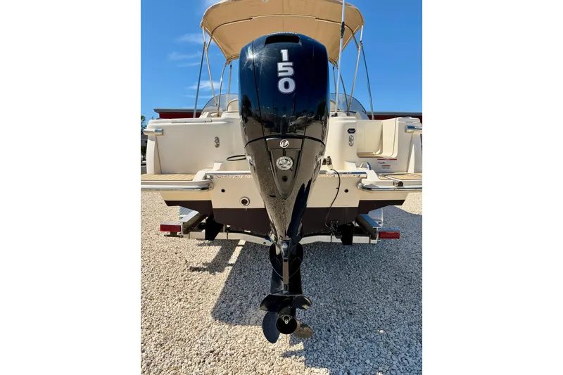Slide: The Image of 2023 Scout 215 Dorado boat with 150 HP outboard motor, parked on gravel. - 31