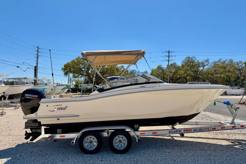 Slide: The Image of 2023 Scout 215 Dorado boat on trailer, featuring a Mercury engine and canopy. - 4