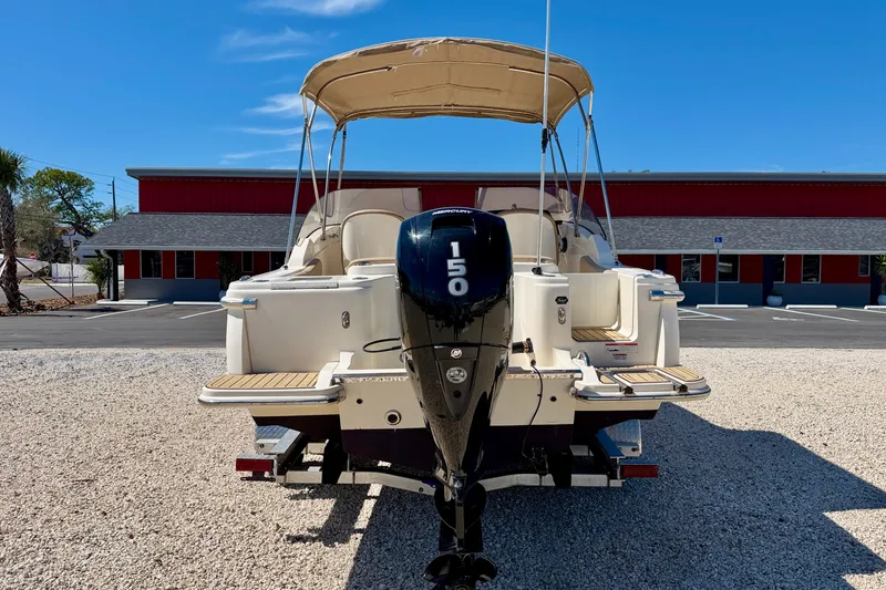 Slide: The Image of 2023 Scout 215 Dorado boat with 150 HP engine, parked on gravel, blue sky background. - 6