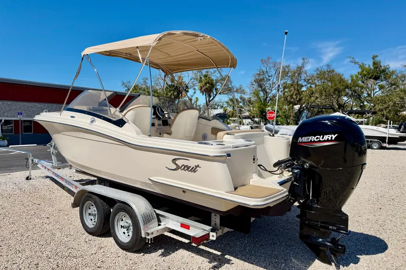 Slide: The Image of 2023 Scout 215 Dorado boat on trailer with Mercury outboard engine, parked outdoors. - 7