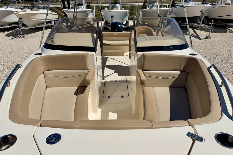 Slide: The Image of 2023 Scout 215 Dorado boat interior with beige seating and dual consoles. - 8