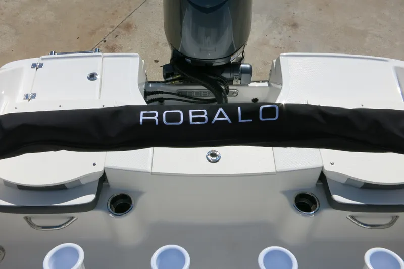 Slide: The Image of 2026 Robalo R180 Center Console boat stern with engine cover and cup holders. - 18