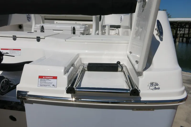 Slide: The Image of 2026 Robalo R180 Center Console boat with open storage compartment and safety warning label. - 20