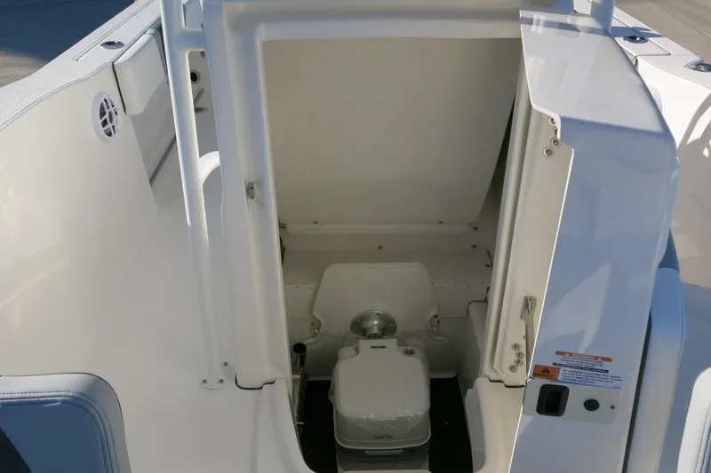 Slide: The Image of 2026 Robalo R200 Center Console boat interior with compact marine toilet. - 20