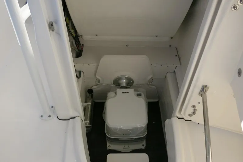 Slide: The Image of 2026 Robalo R200 Center Console boat interior with compact marine toilet. - 21