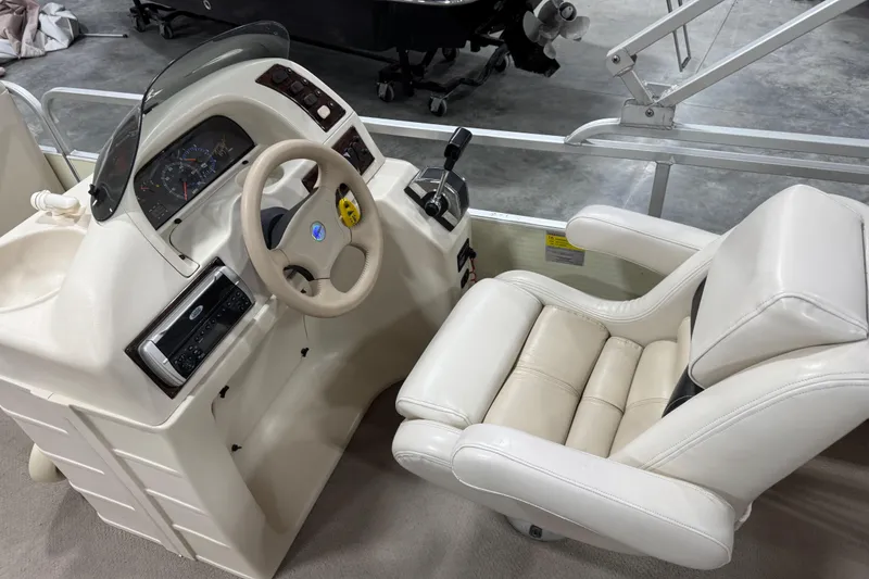 Slide: The Image of Captain's seat and helm of 2002 Voyager Extreme 25 Cruise boat, featuring steering wheel and controls. - 10