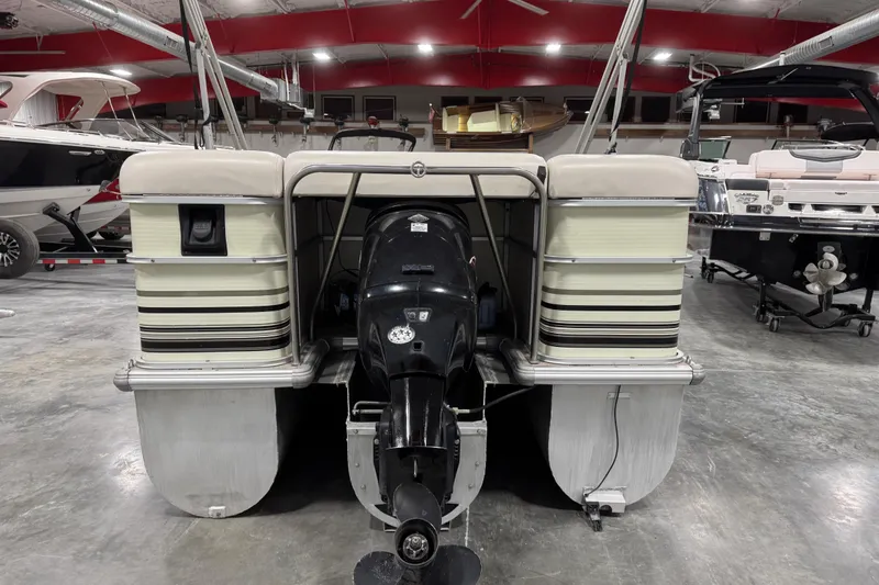 Slide: The Image of 2002 Voyager Extreme 25 Cruise pontoon boat in a showroom, rear view with motor. - 6