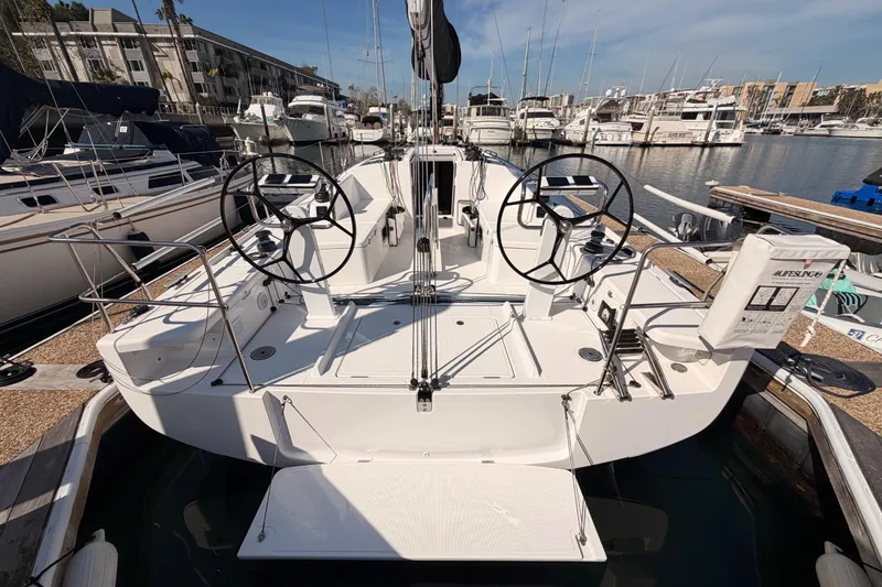 Slide: The Image of 2023 Beneteau First 36 sailboat docked at marina, featuring dual steering wheels. - 10