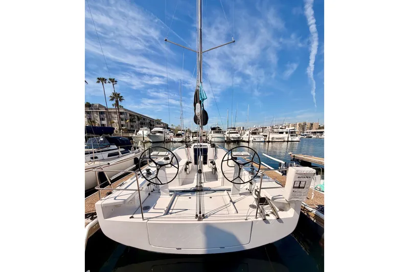 Slide: The Image of 2023 Beneteau First 36 sailboat docked at a marina under a clear blue sky. - 103