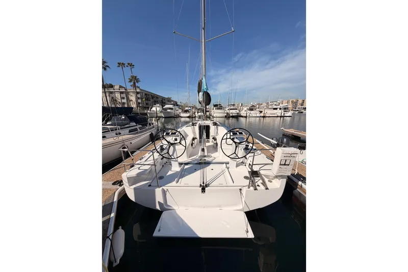 Slide: The Image of 2023 Beneteau First 36 sailboat docked in a marina under clear blue skies. - 11
