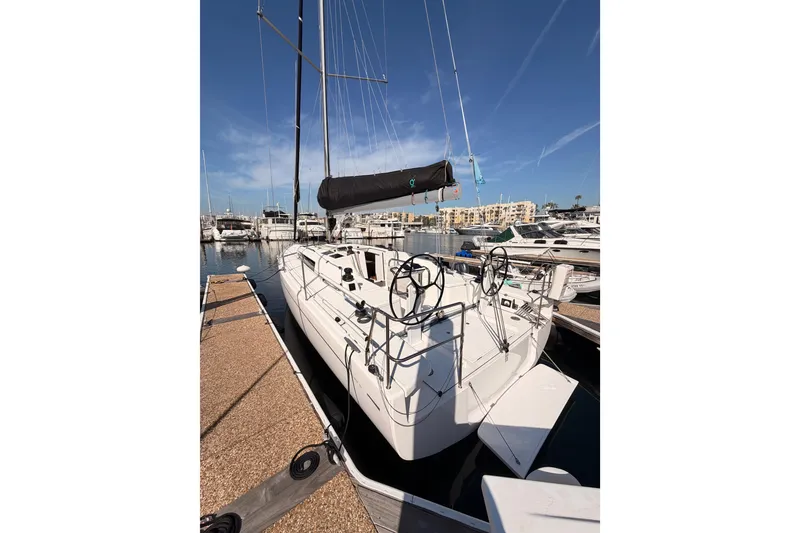 Slide: The Image of 2023 Beneteau First 36 sailboat docked at marina under clear blue sky. - 12