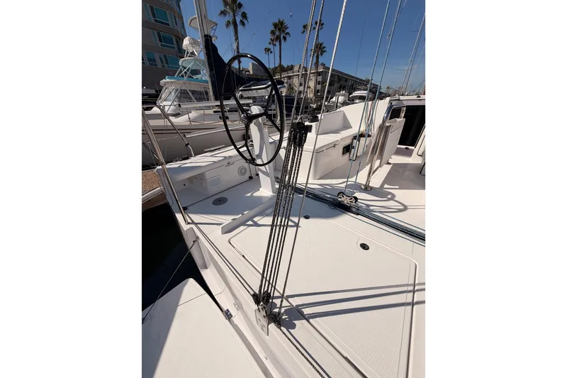 Slide: The Image of 2023 Beneteau First 36 sailboat deck with steering wheel and rigging. - 13