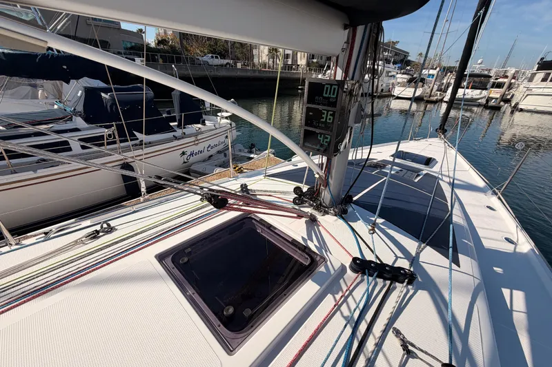 Slide: The Image of 2023 Beneteau First 36 sailboat deck with rigging and digital displays in a marina. - 23
