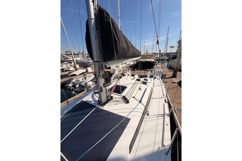 Slide: The Image of 2023 Beneteau First 36 sailboat docked at marina under clear blue sky. - 33