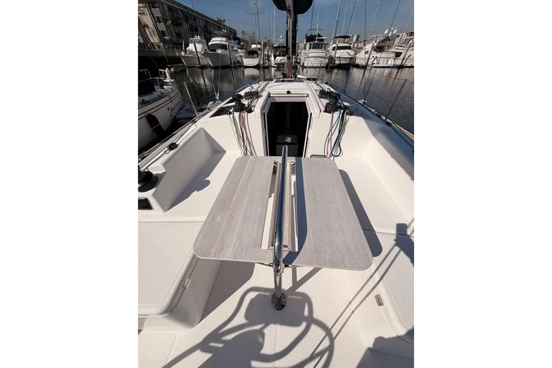 Slide: The Image of 2023 Beneteau First 36 sailboat cockpit with table, docked in marina. - 47