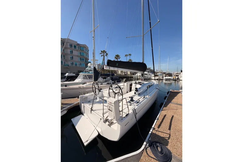 Slide: The Image of 2023 Beneteau First 36 sailboat docked at marina under clear blue sky. - 5