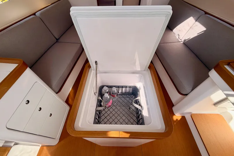 Slide: The Image of Interior of 2023 Beneteau First 36 yacht with open cooler and seating area. - 57
