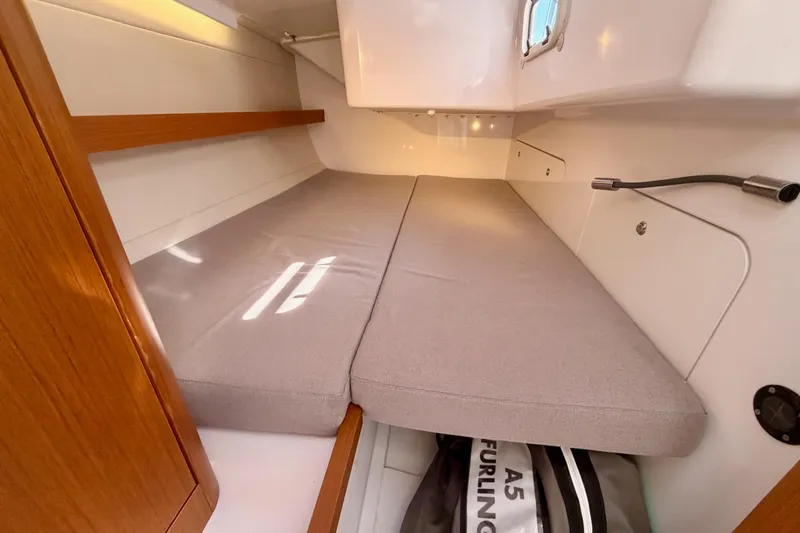 Slide: The Image of 2023 Beneteau First 36 cabin interior with cushioned berth and storage space. - 68