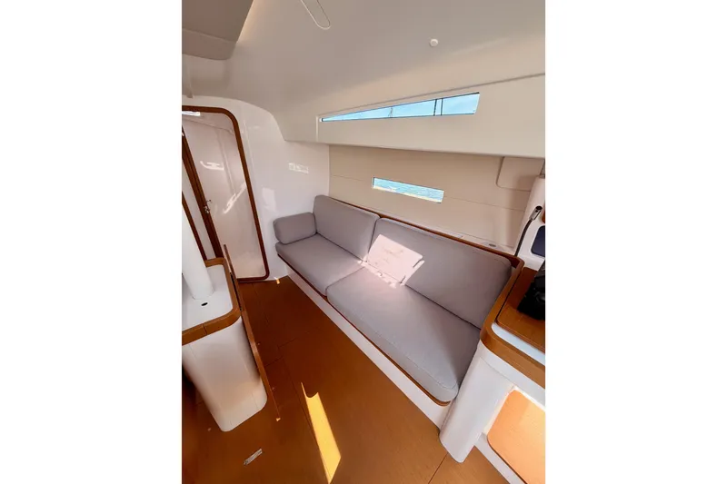 Slide: The Image of Interior of 2023 Beneteau First 36 yacht, featuring a modern, minimalist design with a comfortable sofa. - 79