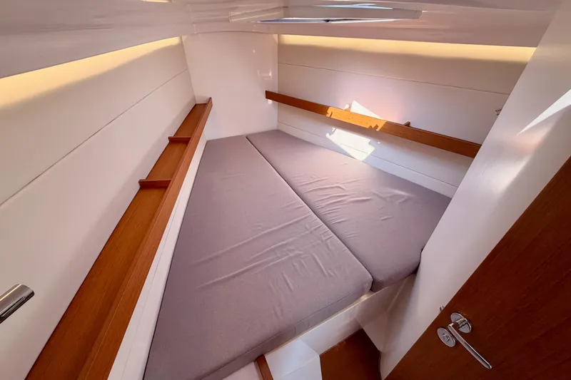 Slide: The Image of 2023 Beneteau First 36 cabin interior with cozy bed and wooden accents. - 86