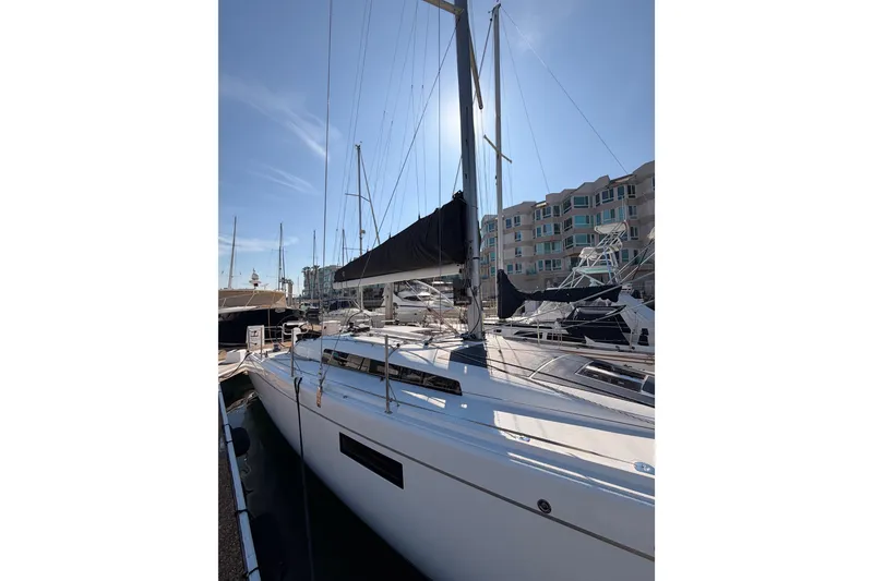 Slide: The Image of 2023 Beneteau First 36 sailboat docked at marina under clear blue sky. - 9