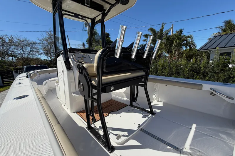 Slide: The Image of 2019 Everglades 243 Center Console boat with rod holders and seating, under clear blue sky. - 8