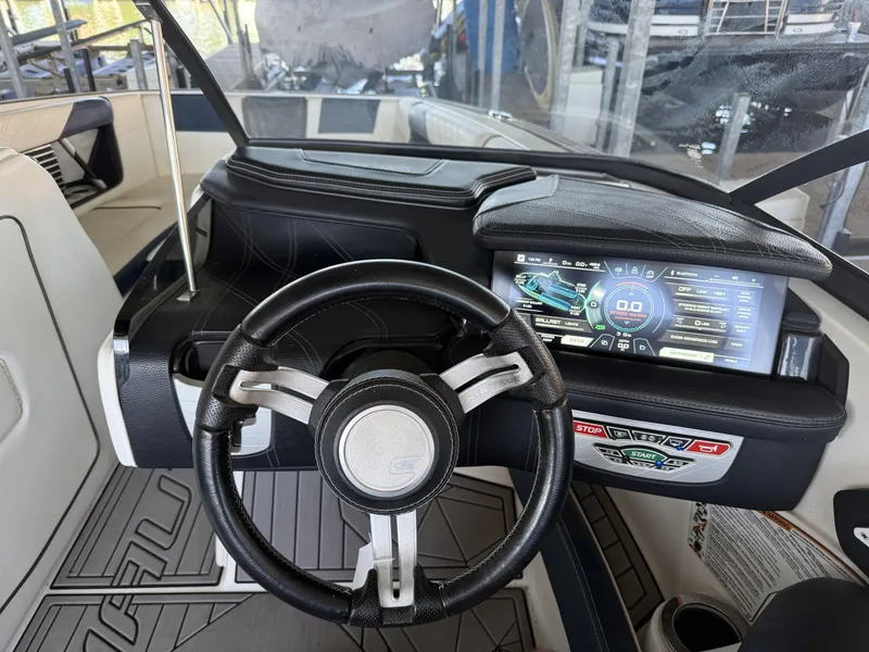 Slide: The Image of Interior view of a 2018 Nautique G23 boat with steering wheel and display. - 11