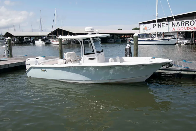 Slide: The Image of 2023 Sea Hunt Ultra 265 SE boat docked at marina with sailboats in background. - 0