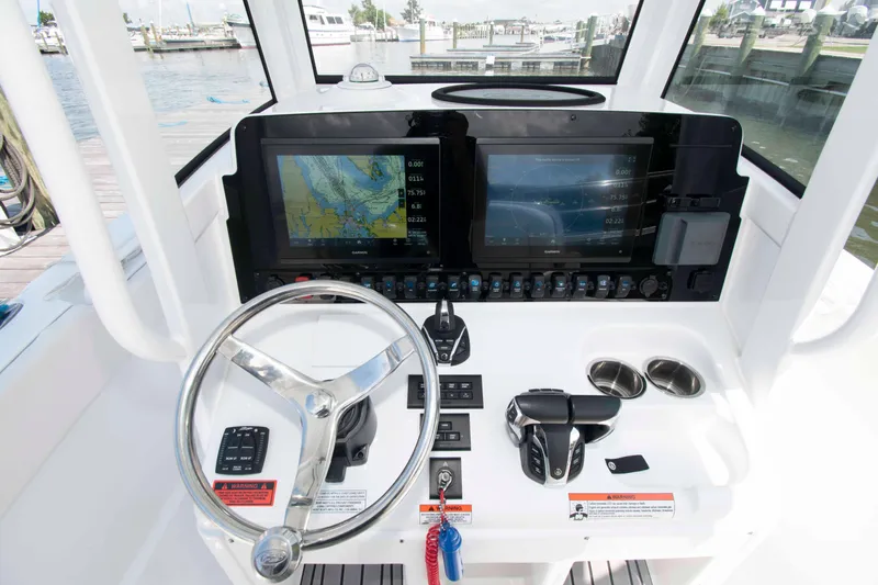 Slide: The Image of 2023 Sea Hunt Ultra 265 SE boat dashboard with dual navigation screens and steering wheel. - 10
