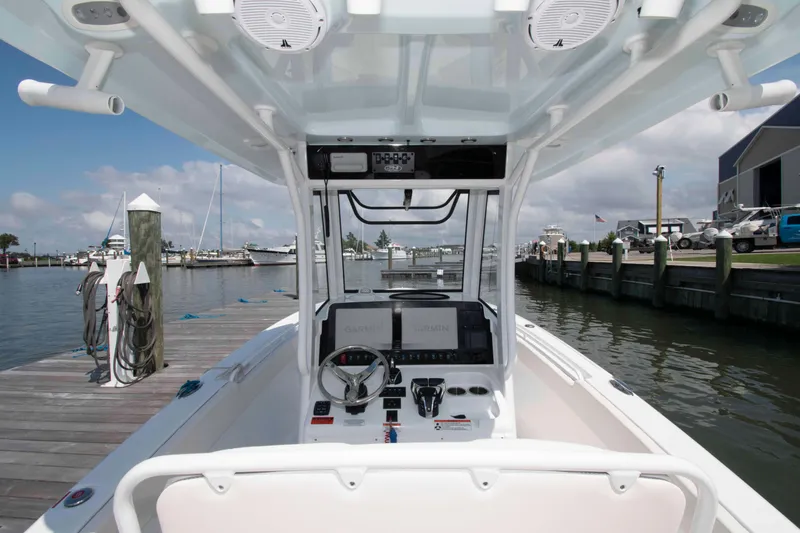 Slide: The Image of 2023 Sea Hunt Ultra 265 SE boat at marina dock, featuring modern helm controls. - 11