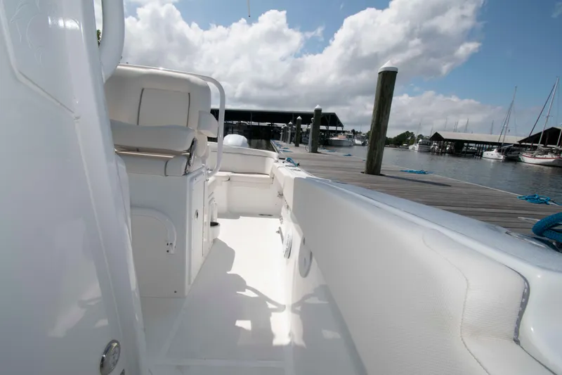 Slide: The Image of 2023 Sea Hunt Ultra 265 SE boat interior at marina dock, under cloudy sky. - 15