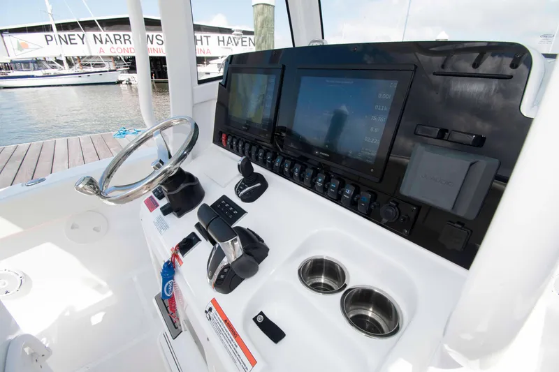 Slide: The Image of 2023 Sea Hunt Ultra 265 SE boat dashboard with steering wheel and electronic controls. - 5
