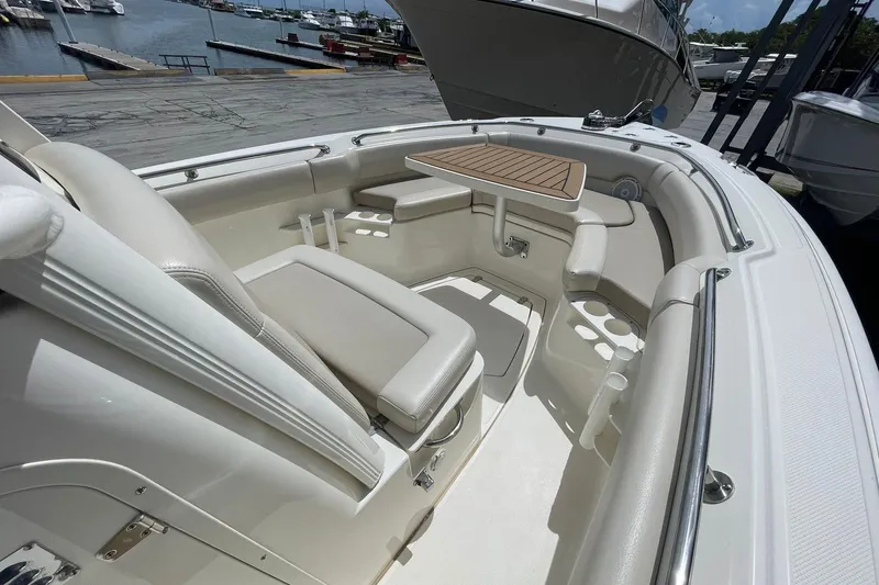 Slide: The Image of 2021 Boston Whaler 230 Outrage boat interior with seating and table, docked at marina. - 6