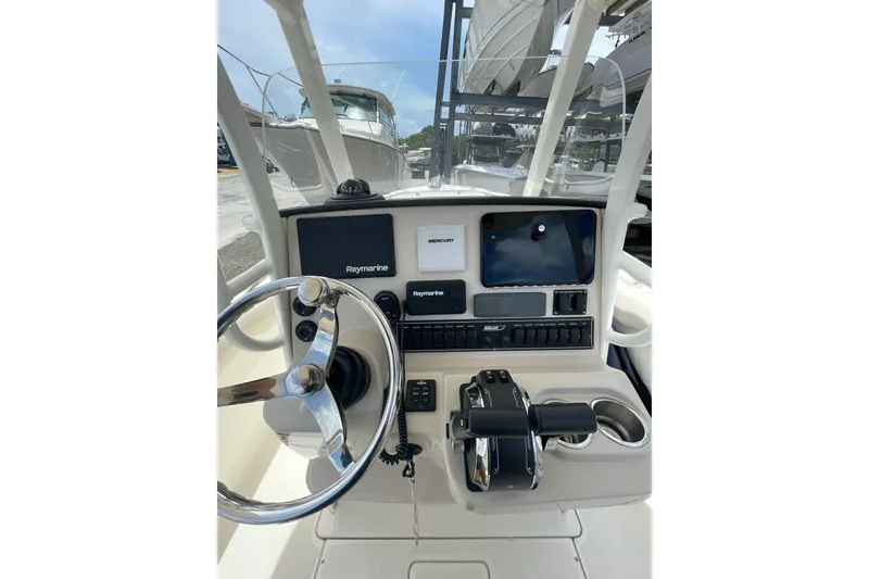 Slide: The Image of 2021 Boston Whaler 230 Outrage boat dashboard with steering wheel and navigation controls. - 9