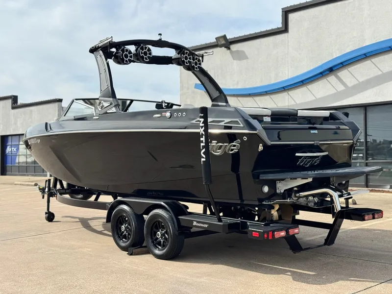 Slide: The Image of Black 2018 Tigé 23RZX boat on trailer in front of building. - 3