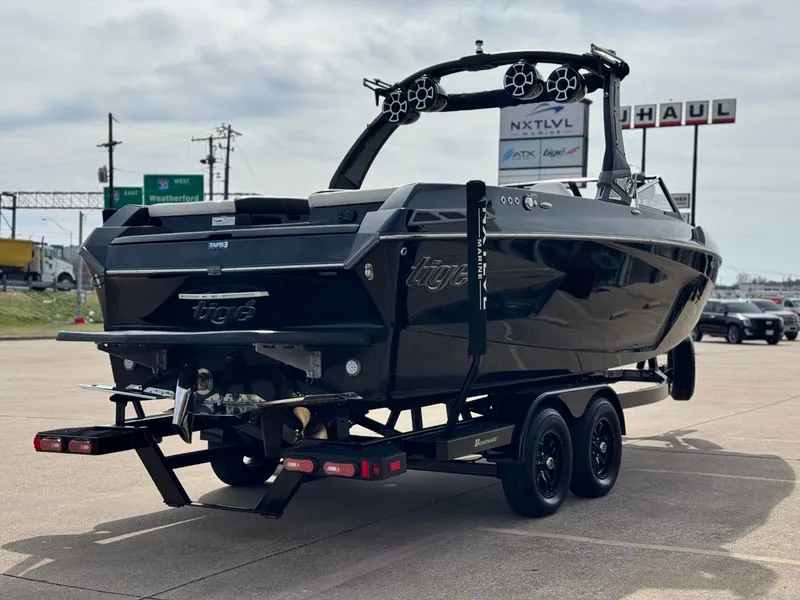 Slide: The Image of Black 2018 Tigé 23RZX boat parked on trailer. - 5
