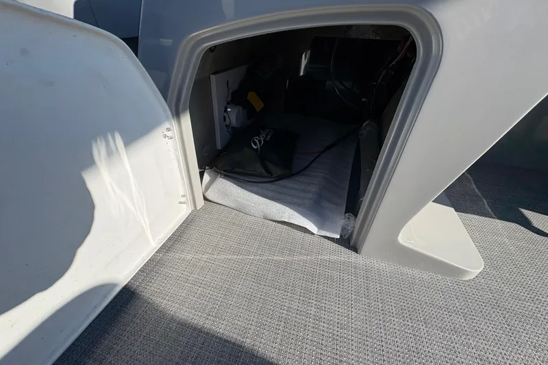 Slide: The Image of Storage compartment in 2026 Bentley Pontoons Fish 220 FWD CW boat, featuring carpeted interior. - 23