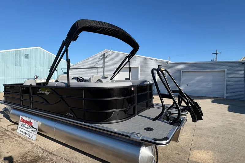 Slide: The Image of 2026 Bentley Pontoons Fish 220 FWD CW, black pontoon boat with canopy, docked outdoors. - 7