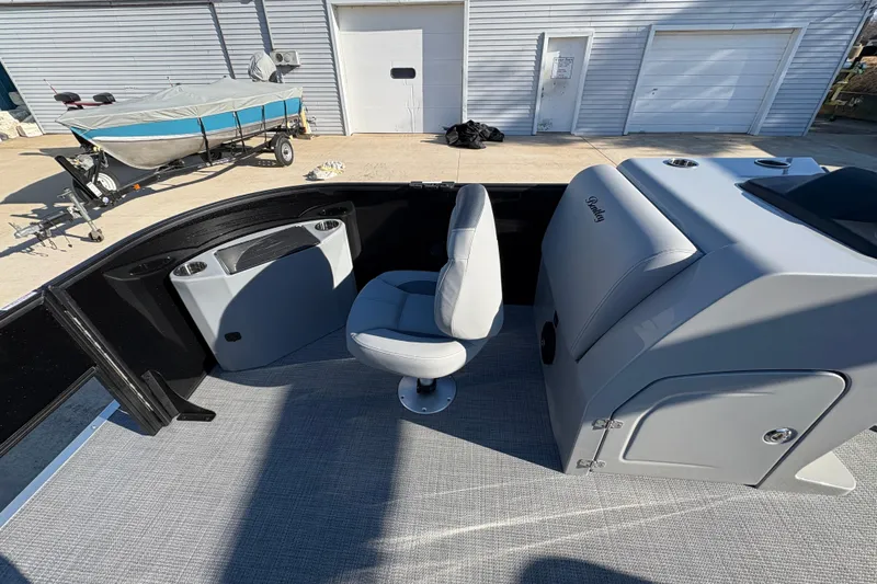Slide: The Image of 2026 Bentley Pontoons Fish 220 FWD CW interior with seating and console, parked outdoors. - 9