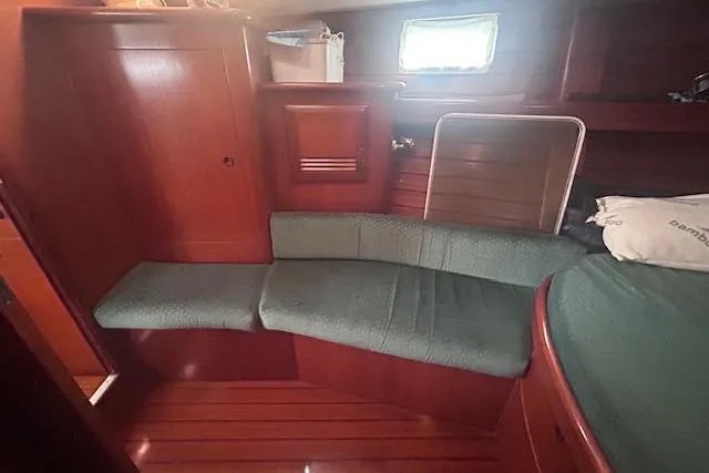 Slide: The Image of Interior of 2001 Beneteau Oceanis 461 sailboat with wooden finish and green seating. - 19