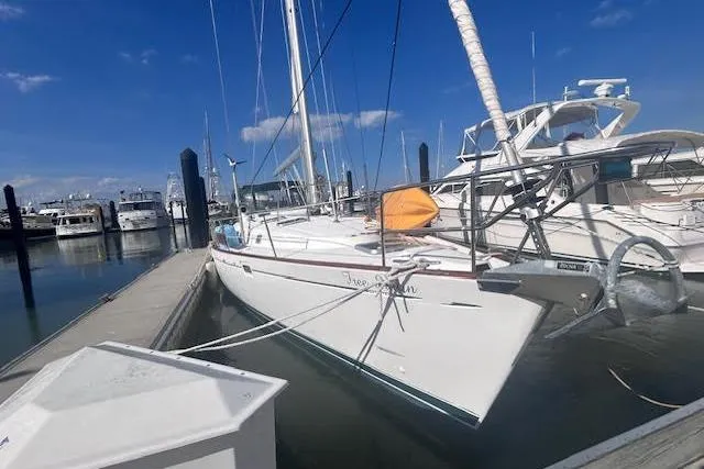 Slide: The Image of 2001 Beneteau Oceanis 461 sailboat docked in a marina under a clear blue sky. - 2