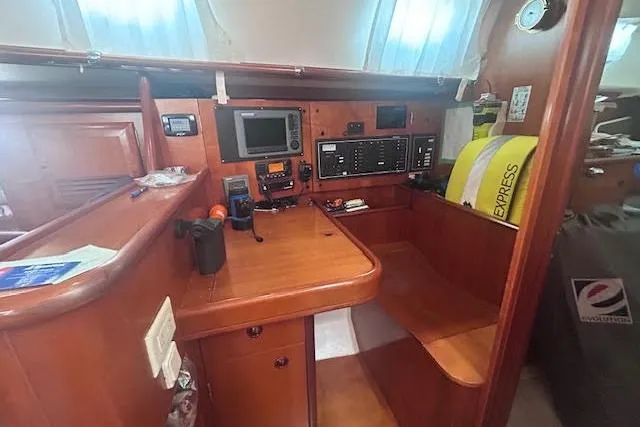 Slide: The Image of Navigation station inside 2001 Beneteau Oceanis 461 sailboat, featuring control panels and equipment. - 20