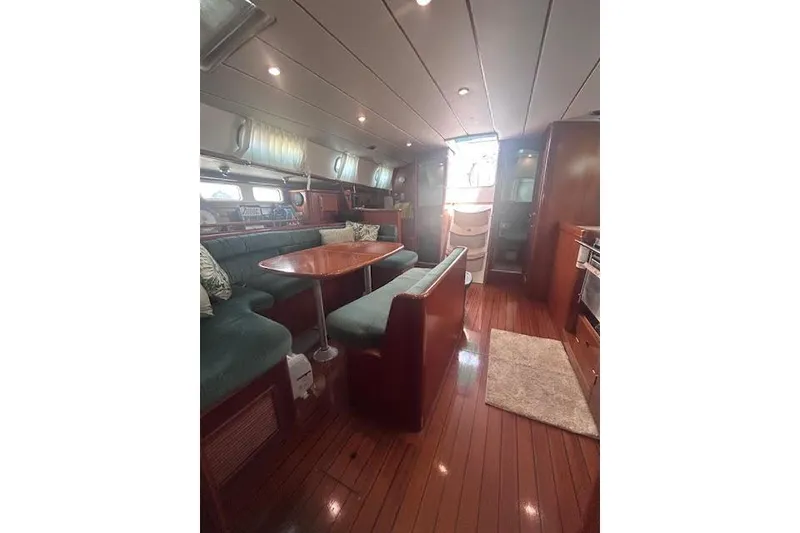 Slide: The Image of Interior of 2001 Beneteau Oceanis 461 yacht with wooden flooring and cozy seating area. - 22