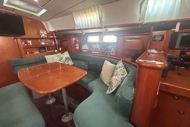 Slide: The Image of Interior of 2001 Beneteau Oceanis 461 yacht with cozy seating and wooden table. - 23