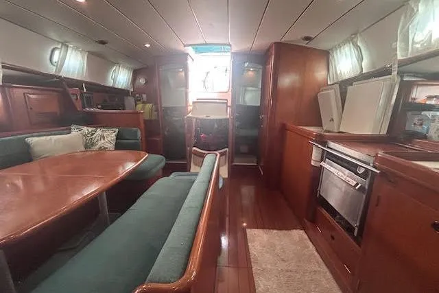 Slide: The Image of Interior of 2001 Beneteau Oceanis 461 yacht with dining area and kitchen amenities. - 26